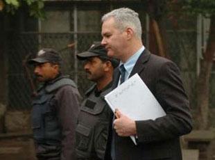 A member of a team from Scotland Yard (R) and police guards leave the mortuary of a local hospital after examining the bodies of the victims of the December 27 suicide bombing in Rawalpindi January 7, 2008.  REUTERS/Stringer