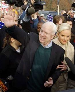Republican presidential candidate U.S. Senator John McCain (C) waves to supporters as he and his wife Cindy make a morning visit to a poling station in Nashua, New Hampshire Jan. 8, 2008. (Xinhua/Reuters Photo)