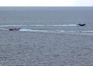 This image released by the U.S Navy Tuesday, Jan. 8, 2008, and shot Sunday, Jan. 6 from the bridge of the destroyer USS Hopper, shows 2 small boats, alleged to be Iranian, purportedly racing near the wake of U.S. Navy ships in the Persian Gulf.(Xinhua/AFP Photo)