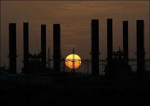 The sun sets behind the main Palestinian electricity company  in the central Gaza Strip. (AFP/Said Khatib) 