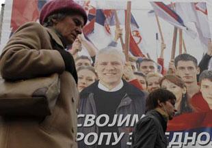 Local residents walk in front of a poster of President Boris Tadic, candidate of the Democratic Party, in Belgrade, capital of Serbia, Jan. 31, 2008. The run-off of Serbian presidential election will be held on Feb. 3. (Xinhua/Wu Xiaoling)