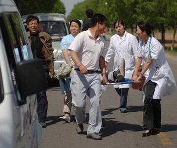 Medical workers carry a person injured by a water tower collapsed in the earthquake to an ambulance in Xunyi county, Shaanxi Province May 12, 2008. A powerful quake, measure 7.8, hit neighboring Sichuan Province's Wenchuan and the tremor was felt in wide areas of China. [Xinhua]