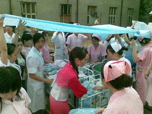 Medical staff and nurses transfer the newborns to a provisional rendezvous at open space, in Chengdu, capital of southwest China's Sichuan Province, May 12, 2008. Chengdu felt strong aftershocks on Tuesday morning, after 9,219 people died in Monday's powerful earthquake, the worst to strike China since the Tangshan earthquake in north China's Hebei Province in 1976, which claimed 242,000 lives.The Sichuan Earthquake Networks reported at 8:00 a.m. Tuesday that they recorded 1,180 aftershocks in the past three hours, with the strongest measuring 6.0 on the Richter scale. The aftershocks included two measuring 6.0 and 11 ones measuring between 5.0 and 5.9.(Xinhua Photo)