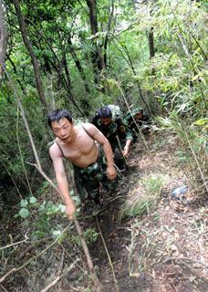 Soldiers carring supplies for the rescue team travel on foot to the crash site of a military helicopter, near the epicenter town of Yingxiu, in the quake-hit Sichuan Province, southwest China, on June 11, 2008. The remains of all 18 people who were aboard the copter, including five crew members and 13 civilians injured in the May 12 earthquake, have all been found by Wednesday. Soldiers traveled to the site to carry out the recovery operation such as carrying the remains and searching for the black box voice recorder.(Xinhua Photo)