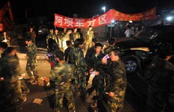 Volunteer militias from Heishui County of the quake-stricken Aba Tibetan Autonomous Prefecture carrying the remains of the crashed military helicopter arrive at Yingxiu Township, Wenchuan County in Southwest China's Sichuan Province in early morning of June 13, 2008.(Xinhua Photo)