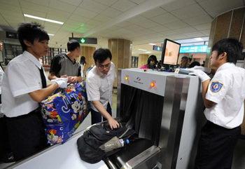 Passengers (2nd, 3rd L) receive security check at a subway station in downtown Beijing, China, June 29, 2008. (Xinhua Photo)