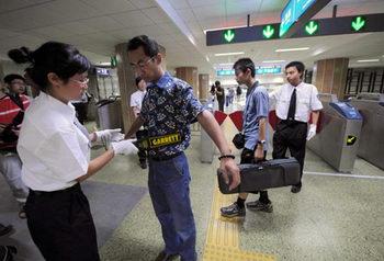 Passengers receive security check at the Andingmen Subway Station in downtown Beijing, China, June 29, 2008. (Xinhua Photo)