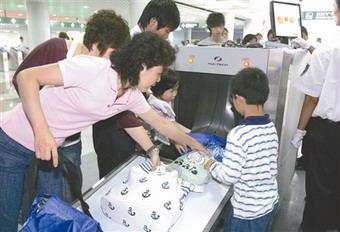 Passengers receive security check at a subway station in downtown Beijing, China,June 29, 2008.