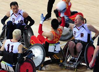 Han Guifei (C) looks to pass under pressure fromScott Hogsett of the US (R) in their mixed wheelchair rugby game at the 2008 Beijing Paralympic Games on September 11, 2008 at the USTB Gymnasium in Beijing. US defeated China 65-30.[Agencies]