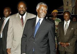 South Africa's former President Thabo Mbeki(C) is welcomed by Zimbabwe's minister of Foreign Affairs Samuel Mumbengegwi(L)on his arrival in Harare.(AFP/Desmond Kwande)