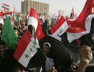 People wave Iraqi flags and chant slogans against a planned Iraqi-US security pact.