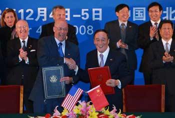 Chinese Vice Premier Wang Qishan (front R) shakes hands with U.S. Treasury Secretary Henry Paulson at a signing ceremony on energy and environmental protection cooperation during the fifth China-U.S. Strategic Economic Dialogue in Beijing, China, Dec. 4, 2008.(Xinhua/Pang Xinglei)