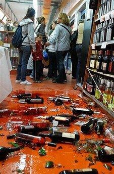 Broken bottles lie on the ground as Israelis stand inside a supermarket after a rocket fired by Palestinian militants landed just outside the store in the southern Israel city of Sderot. Israeli warplanes have carried out two nighttime air strikes against the Gaza Strip following rocket fire against Israel, witnesses have said.(AFP/Moran Buaron)