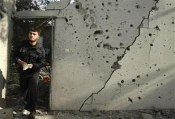A member of Hamas security forces inspects a damaged house following an Israeli airstrike, in the town of Beit Lahiya in the northern Gaza Strip December 18, 2008. An Israeli missile aimed at militants in the north of the Hamas-ruled Gaza Strip killed one Palestinian and slightly wounded another, medical workers said on Wednesday.(Suhaib Salem/Reuters)