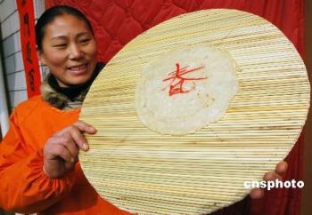 A woman in a village of Tangyin county, Henan province, is displaying some homemade "Chunping" or "Spring Pakcakes" on February 4, 2009, to mark "Lichun", literally known as the beginning of Spring, the first solar term on the Chinese lunar calendar. "Lichun" arrives each year on the first ninth day of the first lunar month on the Chinese calendar. Eating "chunping" is a custom to celebrate the arrival of the season. [Photo: cnsphoto]