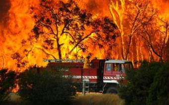 A fire truck moves away from out of control flames from a bushfire in the Bunyip Sate Forest near the township of Tonimbuk, 125 kilometers (78 miles) west of Melbourne, February 7, 2009. Walls of flame roared across southeastern Australia, razing scores of homes, forests and farmland in the sunburned country's worst wildfire disaster in a quarter century.[Agencies]