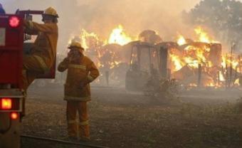 Country Fire Authority volunteers prepare to move to save another house as a barn burns in the background close to Labertouche, west of Melbourne. Troops and firefighters fought raging Australian wildfires on Monday that have left at least 126 people dead amid a landscape of charred bodies, homes and devastated communities.(AFP/William West)