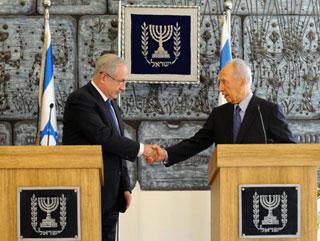 Israeli President Shimon Peres (R) shakes hands with Likud Chairman Benjamin Netanyahu during a joint press conference in Jerusalem, Feb. 20, 2009. Peres officially entrusted Netanyahu with the task of building a coalition Friday afternoon, 10 days after the parliamentary election. (Xinhua/Yin Bogu)