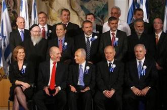 Israel Prime Minister Ehud Olmert, second left, turns to Israeli President Shimon Peres , center, as they sit with the leaders of the various Israeli political parties that form the 18th Parliament posing for a group picture in the Knesset after the Knesset Members were sworn in Tuesday, Feb. 24, 2009.(AP Photo/Jim Hollander, Pool)