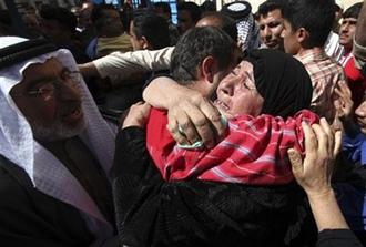 Freed Iraqi prisoner Ahmad Jabbar, centre, embraces his mother Um-al Ahmad, with his father Abu Ahmad on the left, after being released at the Um Al-Quraa mosque in western Baghdad, Iraq, Thursday, March 19, 2009.  (AP Photo/Karim Kadim)