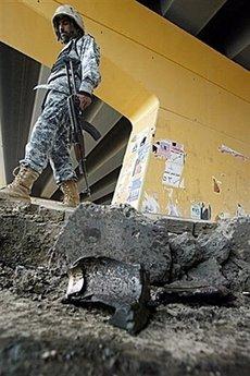 An Iraqi police commando inspects the site where a roadside bomb targeted a police patrol in Baghdad on March 13, 2009. At least 25 people were killed and 50 others were wounded in a suicide bomb attack as a Kurdish family was receiving condolences northeast of the Iraqi capital on Monday, local officials said.(AFP/File/Ali Yussef)