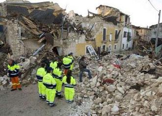 Rescue workers view destroyed houses the morning after an earthquake struck the Italian village of Onna April 7, 2009. REUTERS/Chris Helgren
