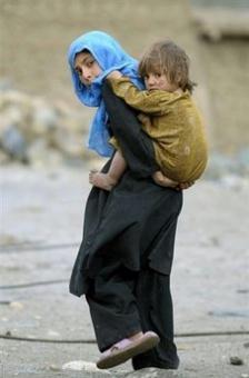 An Afghan girl carries her little sister in Naray, Afghanistan's eastern Kunar province. In four isolated districts of Afghanistan, attacks on the NATO-led International Security Assistance Force rose 120 percent in February and March from a year earlier as coalition troops have started to push deeper into the harsh terrain where militants have been fighting for decades.(AFP/File/Liu Jin)