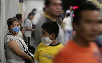 A woman wears a mask as a precaution against swine flu in the subway in Mexico City, Monday, May 4, 2009. (AP Photo/Gregory Bull)