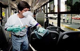 A metrobus worker cleans one of the units as part of the cleaning campaign of public transportation in Mexico City to avoid contagion by the influenza A virus.(AFP/Omar Torres)