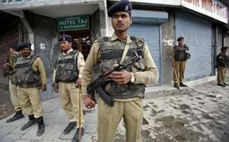 Indian police personnel stand guard at a security barricade during a strike in Srinagar May 6, 2009. REUTERS/Fayaz Kabli