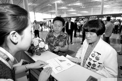 On June 24, Dong Hong (right), a national model worker at Beijing Textile Holdings Company, experiences the procedures for taking a flight at the Terminal 3 of Beijing Capital International Airport, and helps the airport to detect any defects.