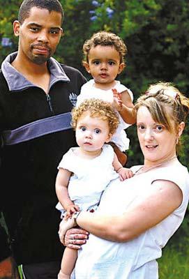 Britain's Dean Durrant pose with his wife Alison Spooner and their two daughters, Lauren and Hayleigh, who were born in 2001 with strikingly different skin tones and eye colors. (Photo: news.cn)